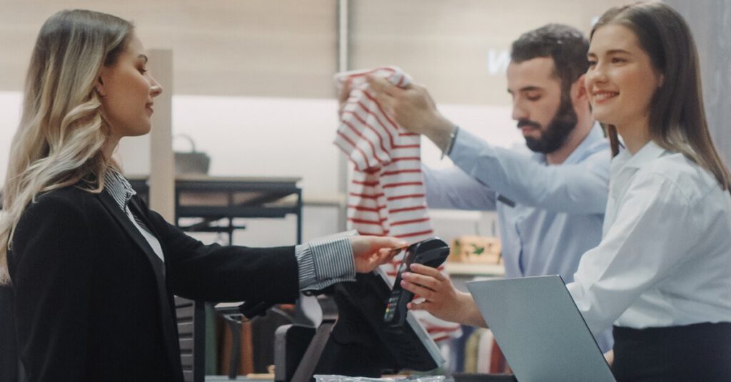 A woman paying with an ePOS system in a retail store