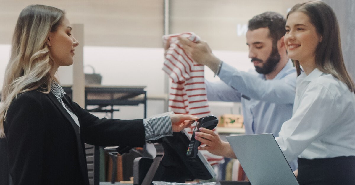 A woman paying with an ePOS system in a retail store