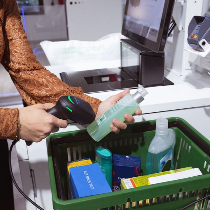 A woman using a self check-out device.