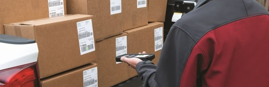 Someone holding a smartphone device to scan packages