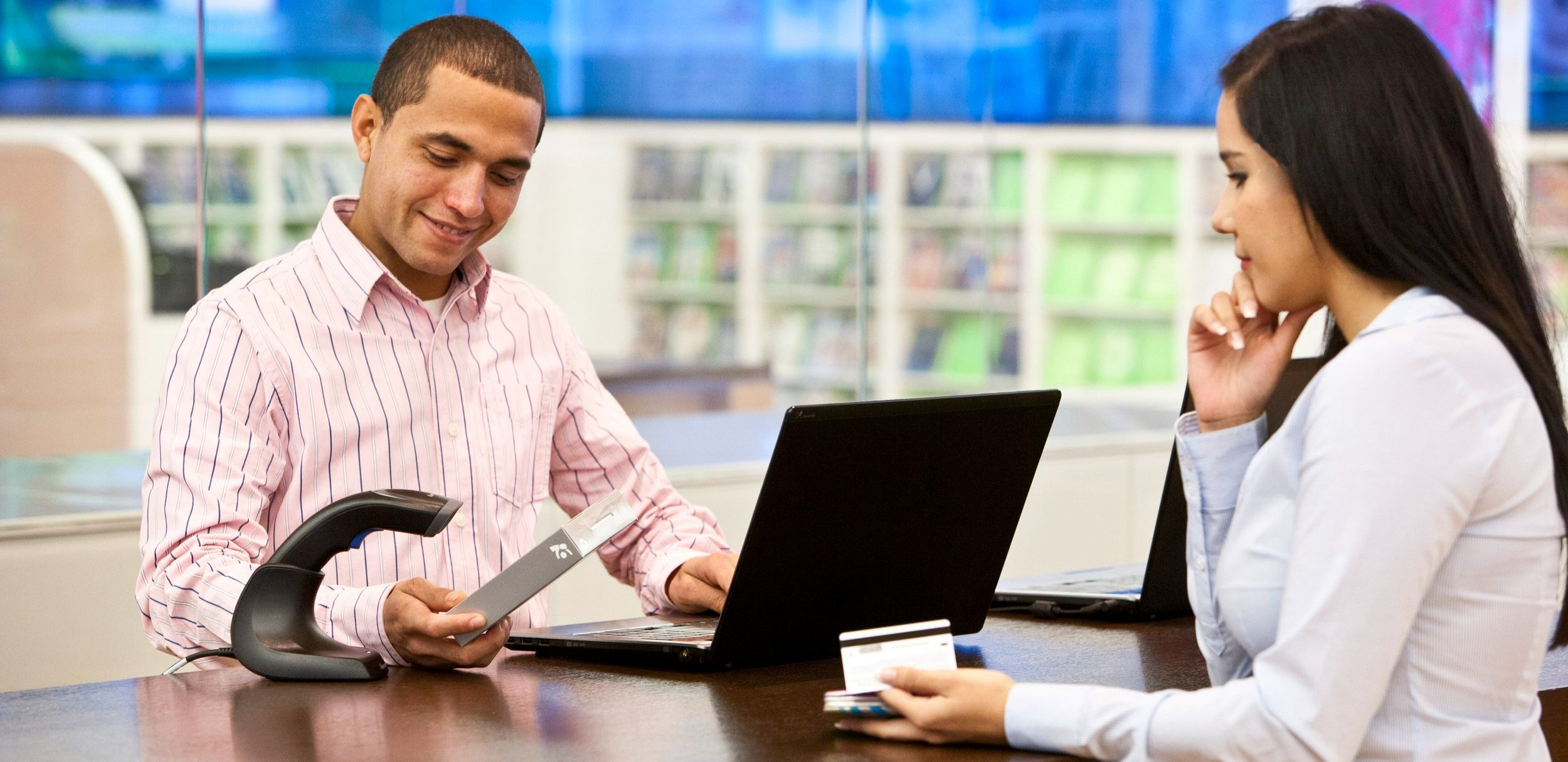 A retail worker using an ePOS device for a purchase