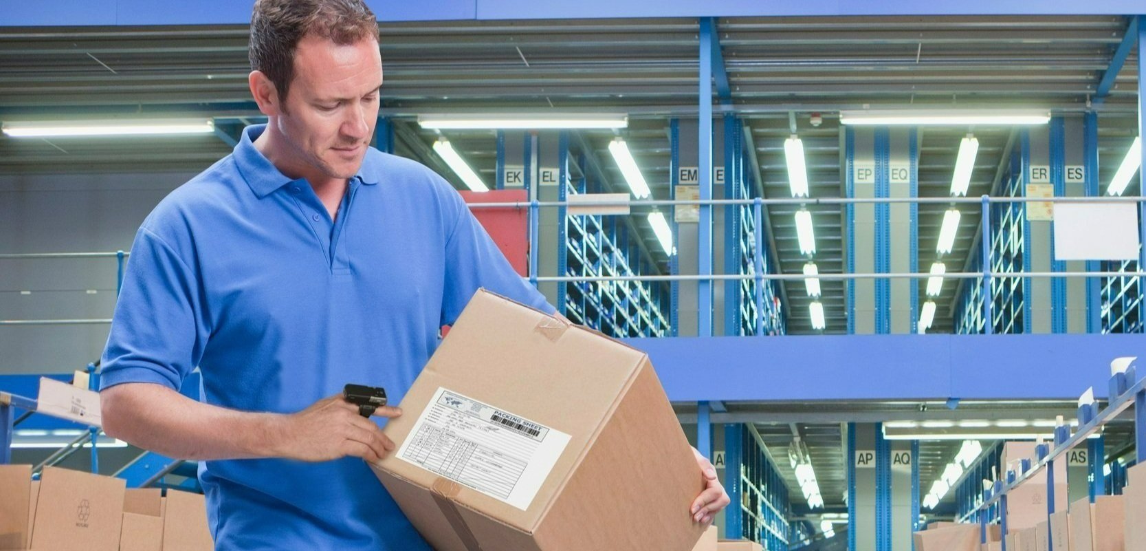 A man using a barcode scanner in a warehouse