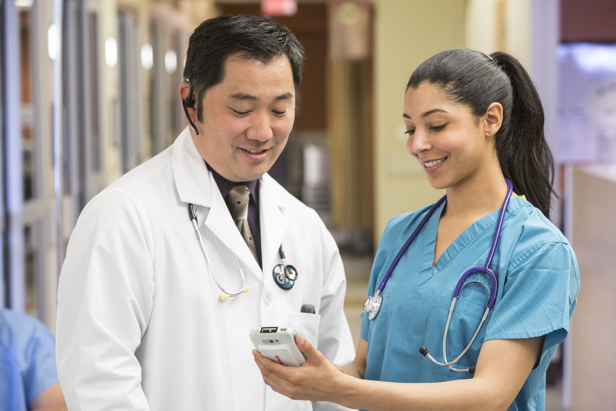 Two doctors looking at a Honeywell mobile computer
