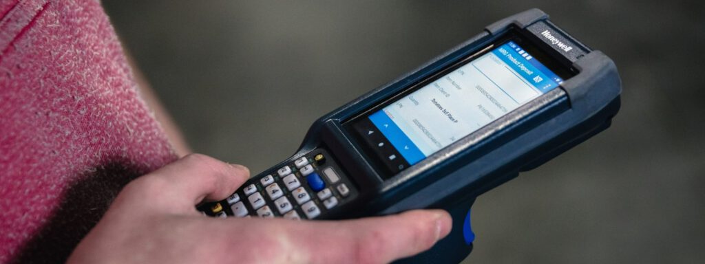 Someone using a handheld Honeywell barcode scanner