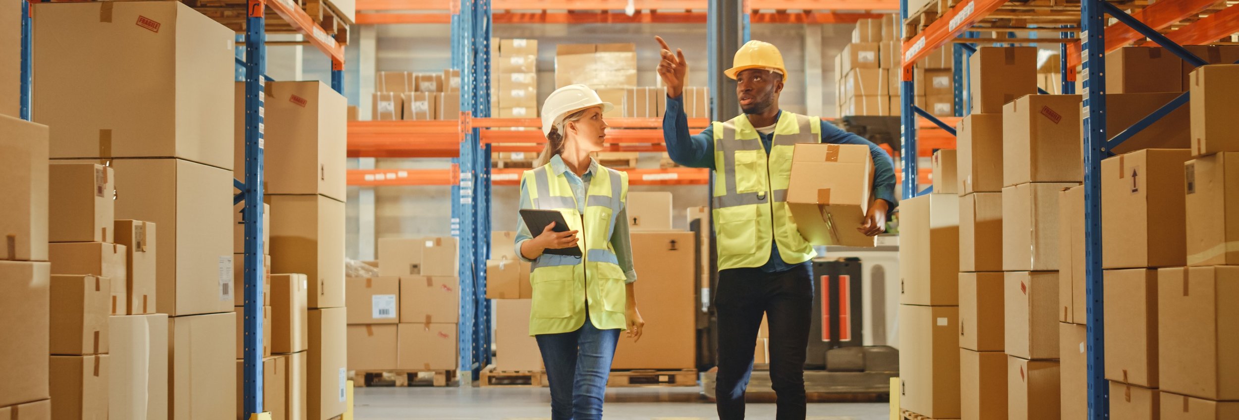 People carrying boxes in the warehouse
