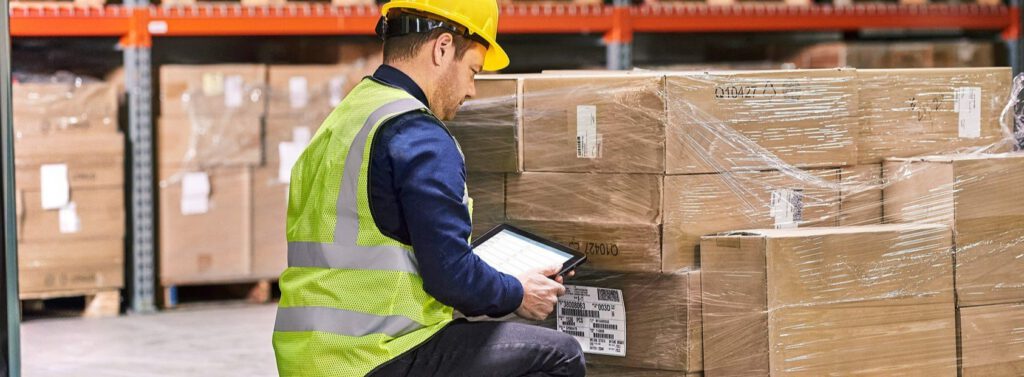 A man using a tablet in a warehouse