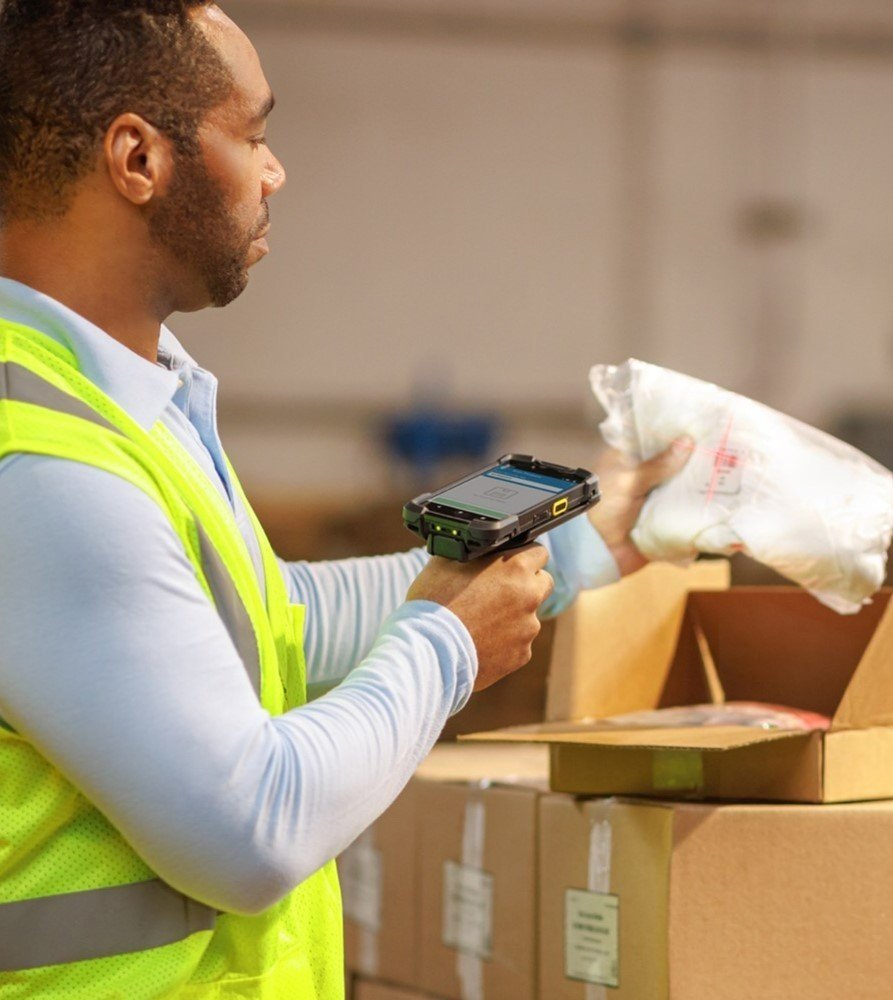 A man using a handheld barcode scanner in a warehouse