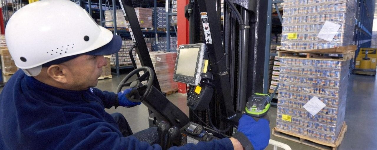 Someone using a Zebra handheld barcode scanner from a forklift in a warehouse