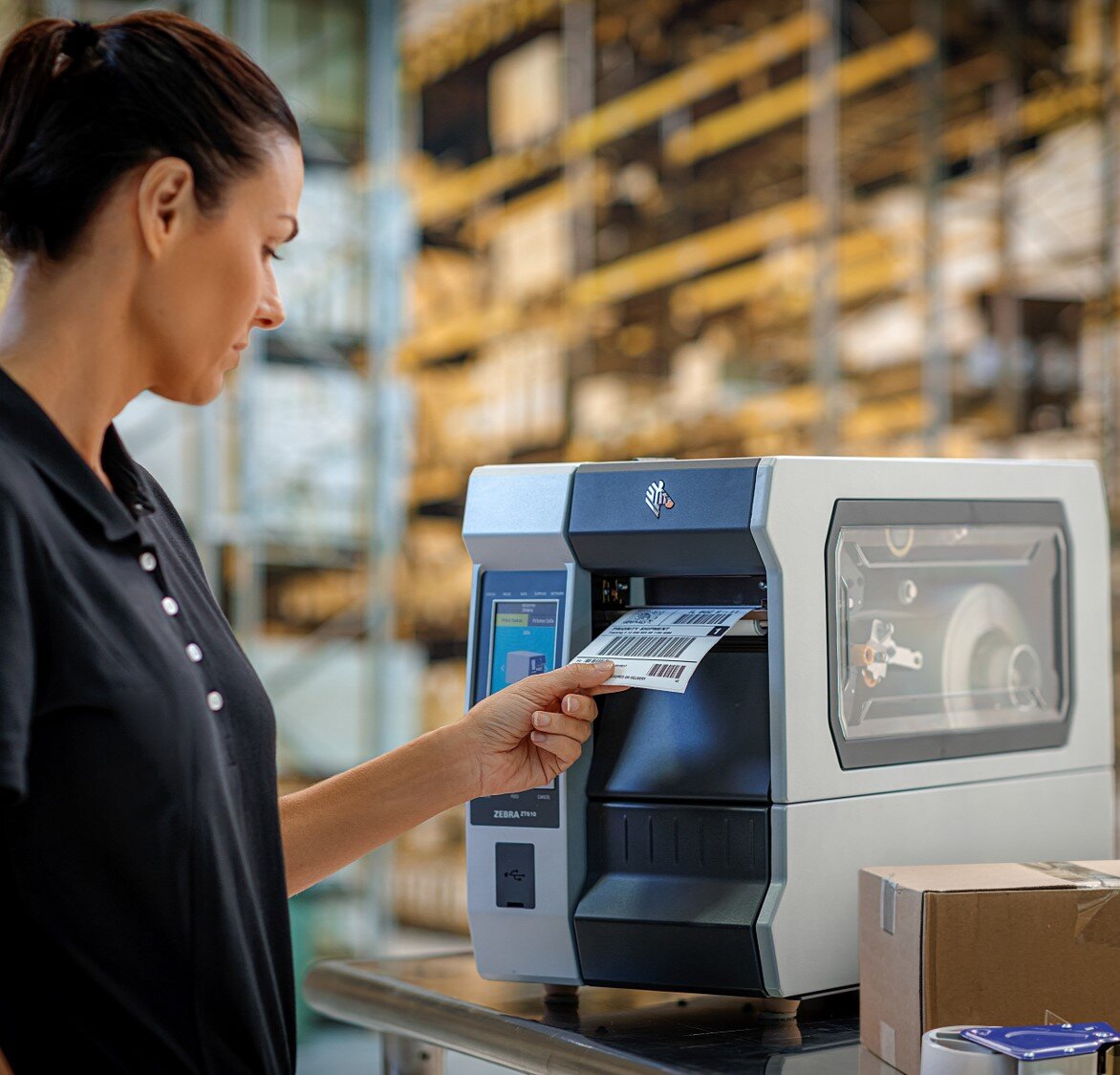 A woman using a Zebra industrial printer