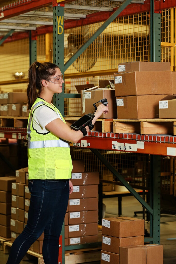 A warehouse worker using a wearable barcode scanner and mobile computer