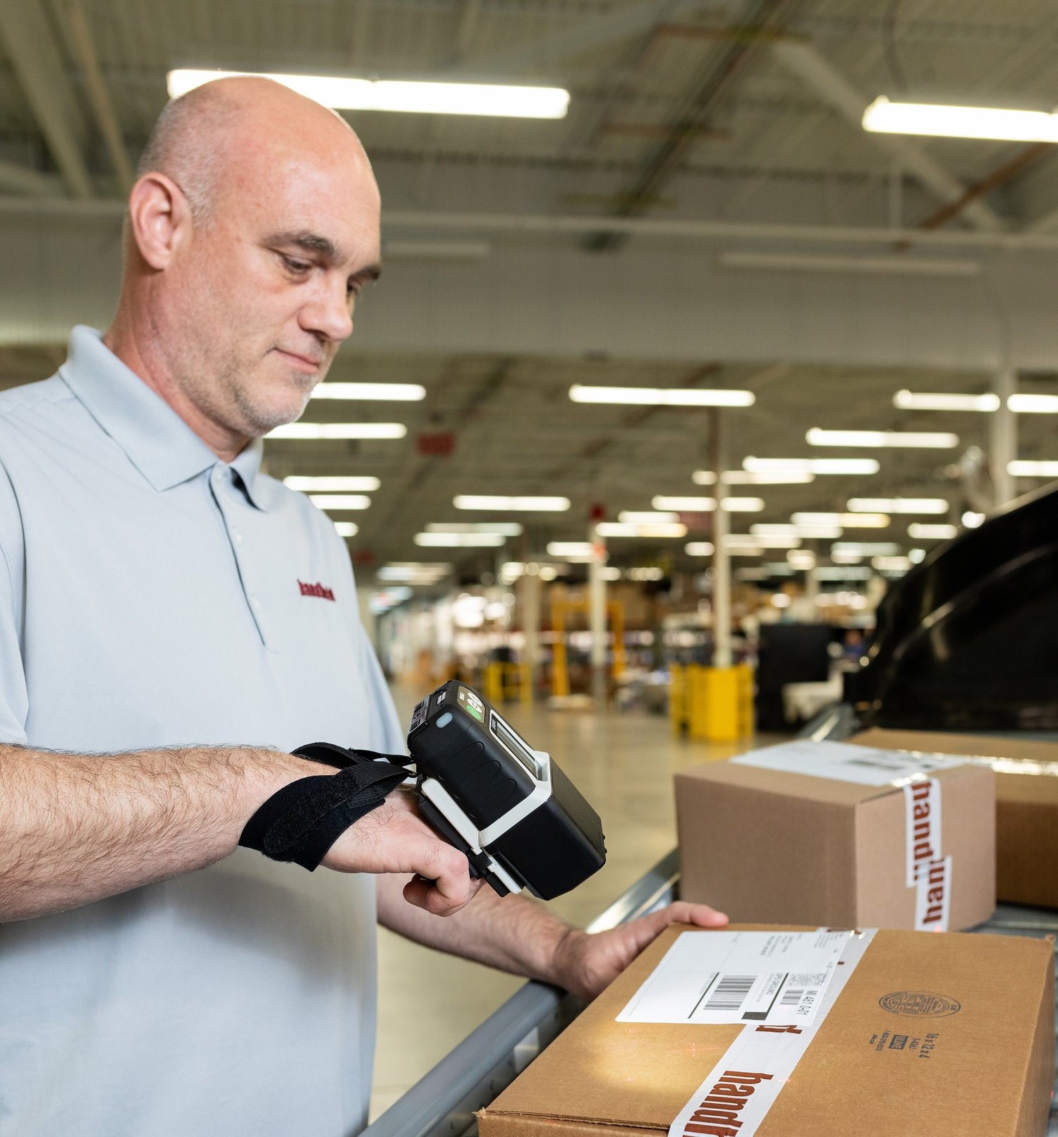 Someone using a wearable barcode scanner for packages