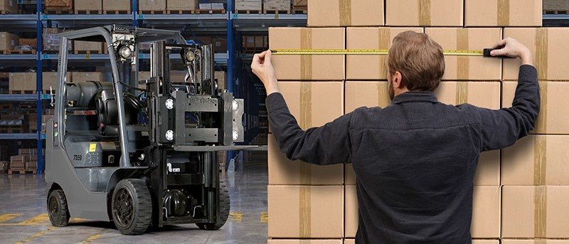 A man measuring packages in a warehouse