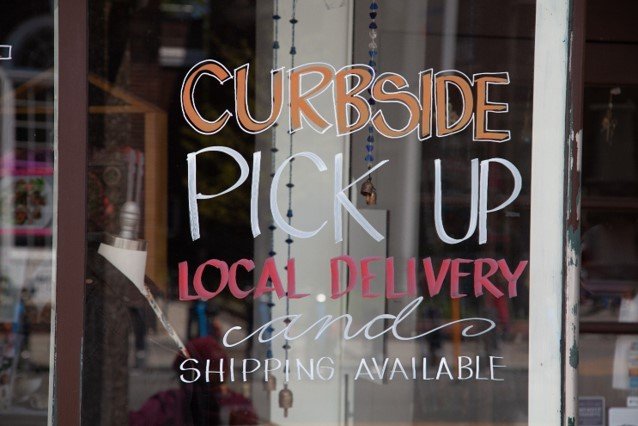 A sign advertising curbside pick-up on a window