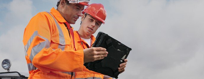 Two men looking at a rugged handheld tablet