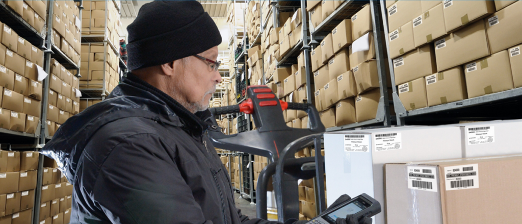 Worker in a cold storage warehouse using a barcode scanner
