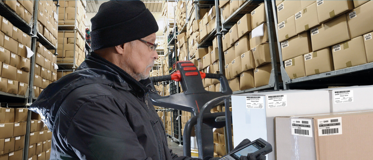 Worker in a cold storage warehouse using a barcode scanner