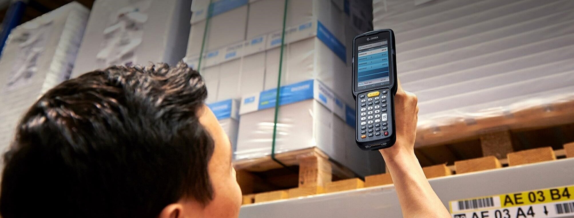 Someone using a Zebra handheld barcode scanner on a package