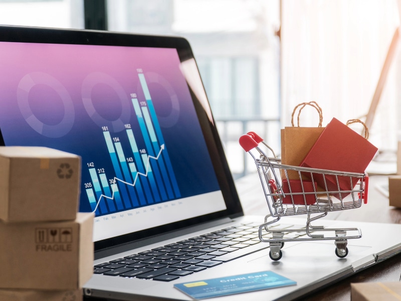 A retail shopping cart on top of a computer