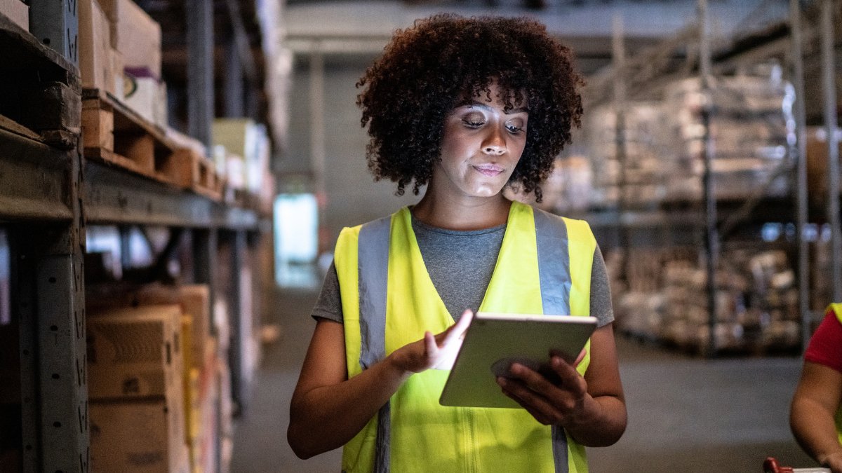 A woman on an iPad in a warehouse