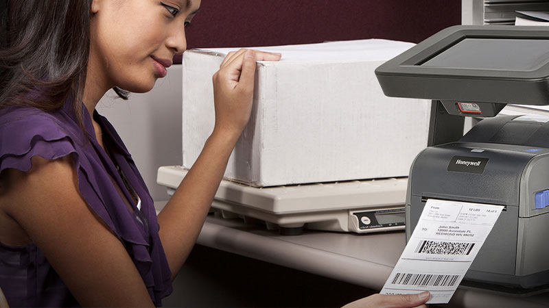 A woman using a Honeywell desktop printer