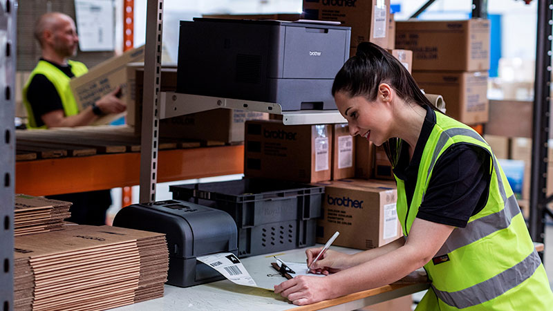 A woman using a warehouse label printer from Brother