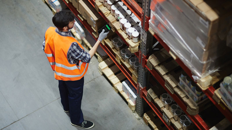 A woman using a mobile computer as a scanner in a warehouse
