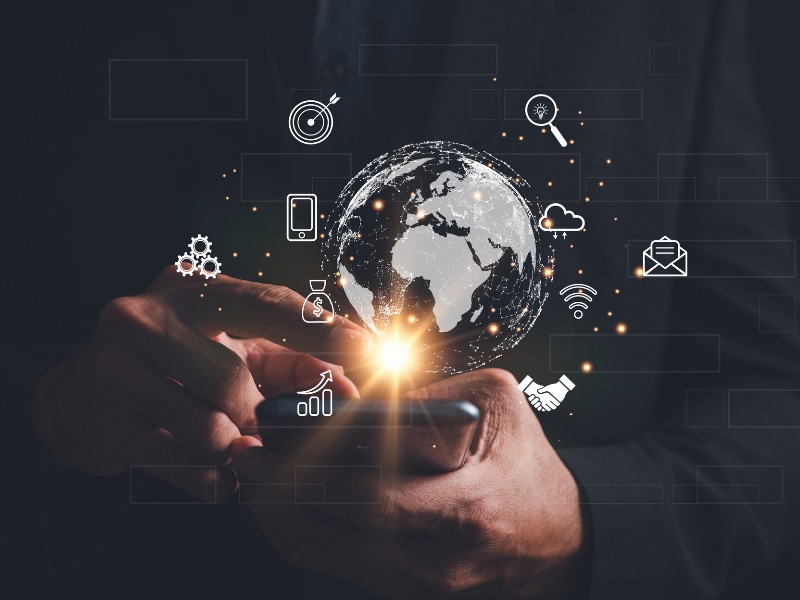 A man holding a globe with icons of IT devices