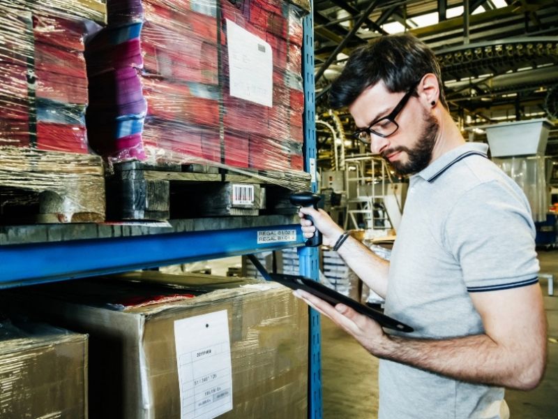 A man using a barcode scanner in a warehouse