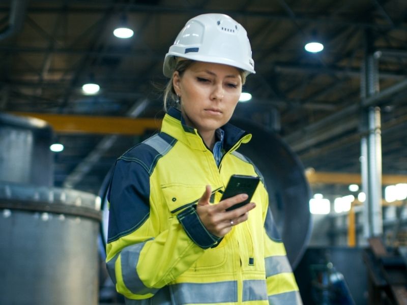 A woman using a mobile device in the warehouse