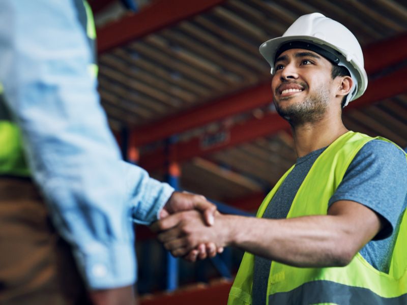 Two men shaking hands in a warehouse
