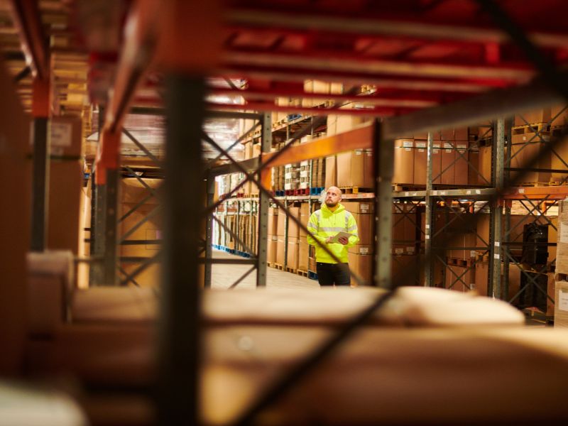 A man in a warehouse with an iPad
